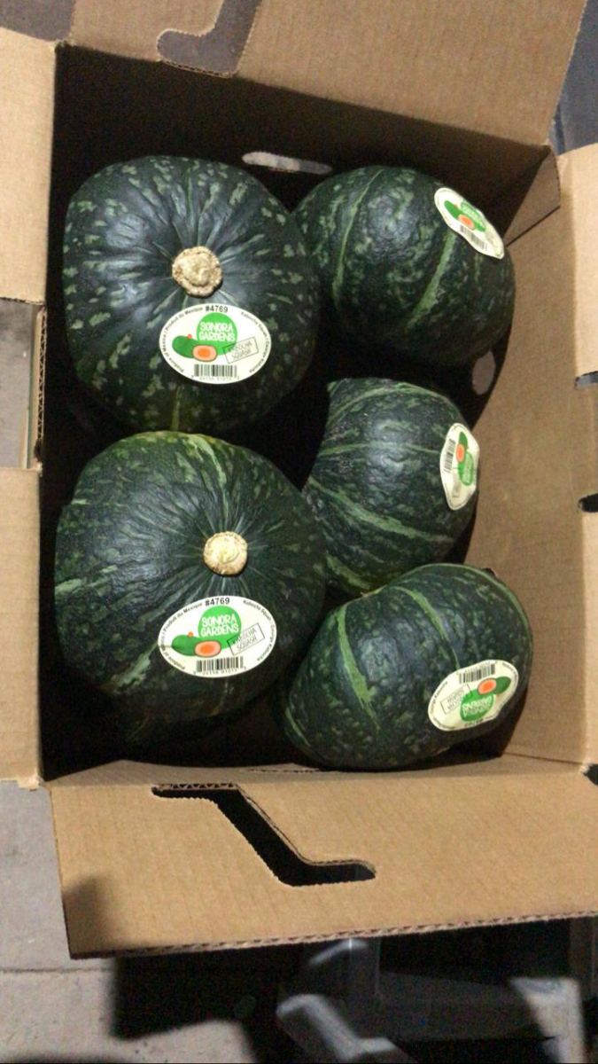 Calabaza kabocha en una caja, cada pieza con etiqueta Sonora Gardens en el PLU 4769